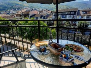 普里兹伦Comfort Hotel Prizren的阳台上的桌子上摆放着比萨饼和饮料