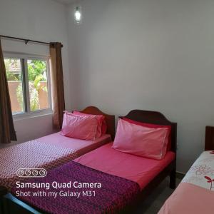 卡图纳耶克Transit Studio Katunayake的客房内的两张床和粉红色枕头