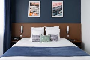 巴黎PLEY Hotel的一间卧室配有一张带蓝色墙壁和枕头的床