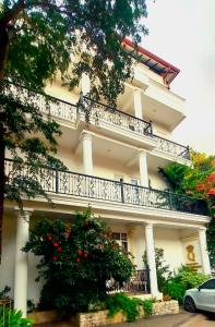 尼甘布Negombo New Queen's Palace的带阳台和树的白色建筑