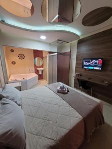 圣保罗Living Hotel Vila Guilherme的一间卧室设有一张大床和一台墙上的电视。