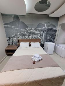 圣保罗Living Hotel Vila Guilherme的卧室配有一张大床,墙上挂有绘画作品