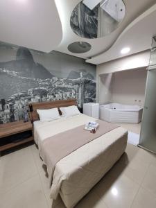 圣保罗Living Hotel Vila Guilherme的卧室配有一张大床,墙上挂有绘画作品