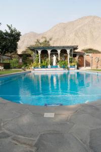 谢内吉亚区Hacienda Santa María de Cieneguilla的一座大游泳池,后面是一座山
