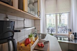 柏林Quiet Courtyard Apartment (PB1)的厨房配有带水果和蔬菜盒的柜台