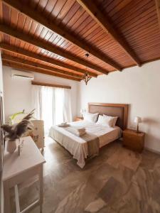 KámposVilla Aelia的一间卧室设有一张大床和木制天花板