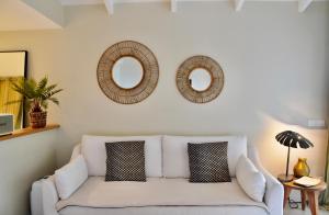 Saint-JeanFranca St Jean的客厅配有白色沙发和两面镜子