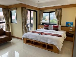 Ban Zong KatiamL18 residence แอลสิบแปด เรสซิเดนซ์的一间卧室设有一张大床、一把椅子和窗户。