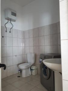 TarrafalSeaview Apartment的浴室配有卫生间、盥洗盆和洗衣机。