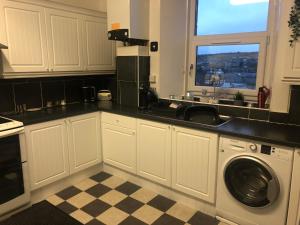 罗撒西Captivating 2-Bed Apartment in Isle of Bute的厨房配有水槽和洗衣机