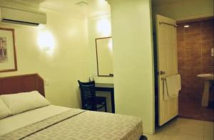 马六甲Hotel Johan的一间卧室配有一张床,浴室设有水槽