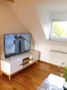 特罗斯多夫Wohnung mit Stil的客厅配有白色橱柜上的平面电视