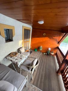 松博特海伊Orsi House的客房设有带桌椅的木制甲板。
