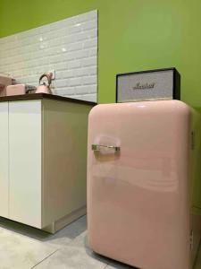 阿尔勒Appartement Ibiz’Arles的盘子旁的粉红色冰箱