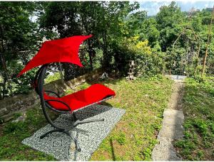扬克斯0-A Diamond in Yonkers, NY的一把红色椅子,上面有一把伞,坐在草地上