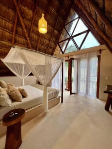 图卢姆Lodge Tzunum Jade的一间卧室配有一张带蚊帐的床