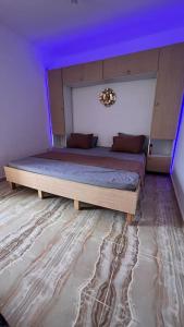 贝贾亚YEMMA GOURAYA LOFT的一间卧室设有两张紫色天花板的床。