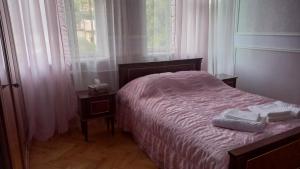 SisianBaleni的一间卧室配有一张床,上面有两条毛巾