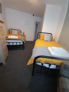 唐克斯特Flat 5 Corner House 1 bedroom的黄色和白色的客房内的两张床
