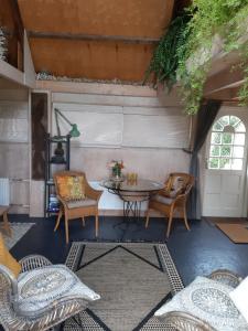 LutjewinkelTuinhuis的一个带椅子和桌子的庭院