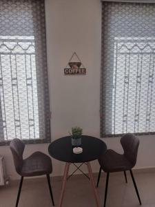安曼Zara's luxury Home- central location near Abdali的一个带两扇窗户的房间,配有一张桌子和两把椅子
