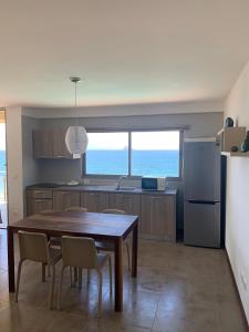 明德卢Lazareto Oceanview的厨房配有桌椅和冰箱。