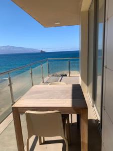 明德卢Lazareto Oceanview的阳台上的木桌和椅子