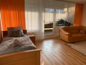 马尔Marl Central Apartment的一间卧室配有一张床、一张沙发和一个窗口