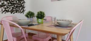 纳瓦雷东达德格雷多斯El Huertecito的餐桌、粉红色椅子和木桌