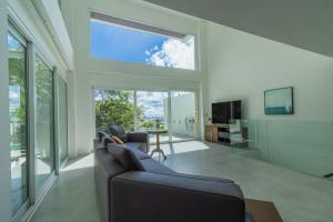 芭东海滩seaview patong private pool sauna 4br villa的带沙发和大窗户的客厅