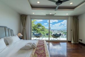 芭东海滩seaview patong private pool sauna 4br villa的一间卧室设有一张大床和一个大窗户