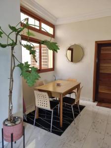 达喀尔Résidence Hadja 01的一间设有木桌和盆栽的用餐室