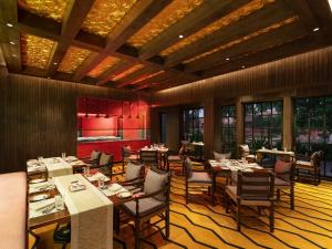 UtordaITC Grand Goa, a Luxury Collection Resort & Spa, Goa的用餐室设有桌椅和窗户。