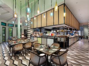 UtordaITC Grand Goa, a Luxury Collection Resort & Spa, Goa的一间带桌椅的餐厅和一间厨房