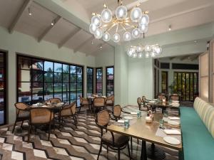UtordaITC Grand Goa, a Luxury Collection Resort & Spa, Goa的一间带桌椅和吊灯的餐厅