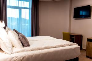 巴尼亚卢卡Hotel IN的卧室配有白色的床和窗户