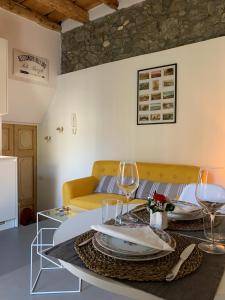 梅纳焦Villa Paola - Holiday Apartment - Menaggio, Lago di Como的客厅配有沙发和带酒杯的桌子
