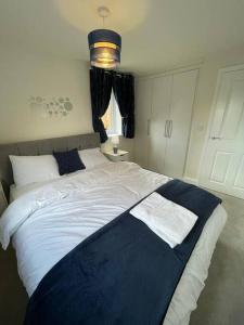 米尔顿凯恩斯Luxurious Apartment in Brooklands的一间卧室配有一张大床,上面有蓝色的毯子