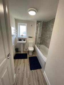 米尔顿凯恩斯Luxurious Apartment in Brooklands的浴室配有卫生间、盥洗盆和淋浴。