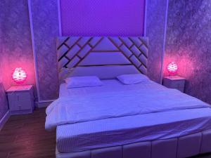 Yanbu Al Bahrشاليه العماريه的紫色卧室配有带两盏灯的床