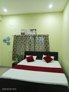王舍城Hotel Narayani的一间卧室配有一张带红色枕头的大床