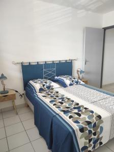 库鲁La Coraline Standing的一间卧室配有一张带蓝色和白色棉被的床
