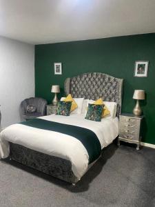 吉夫诺克Saphire Glasgow Apartments的一间卧室设有一张大床和绿色的墙壁