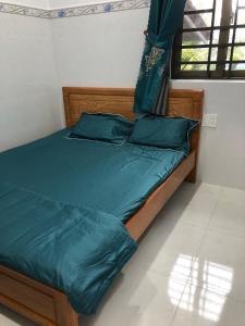 槟知Khách Sạn Vinhomes Huỳnh Hotel的一张带绿床单和枕头的床