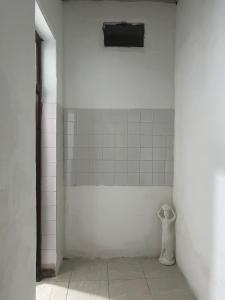 福尔摩沙Mono ambiente céntrico Formosa的一间白色瓷砖房间,墙上挂着一个人