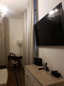 瓦拉泽Varazze Suite Sauna e Hammam的酒店客房的墙上设有大屏幕平面电视。