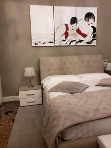瓦拉泽Varazze Suite Sauna e Hammam的卧室配有一张床,墙上挂有两幅画