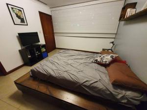 瓜亚基尔Apartamento-suite en la mejor zona de Guayaquil的一间卧室配有一张床和一台平面电视