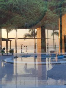 瓜亚基尔Apartamento-suite en la mejor zona de Guayaquil的一座棕榈树建筑在前沿的反射