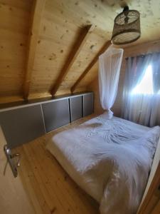 IlijašVikendica Chalet Nišići的木制客房内的一间卧室,配有一张床